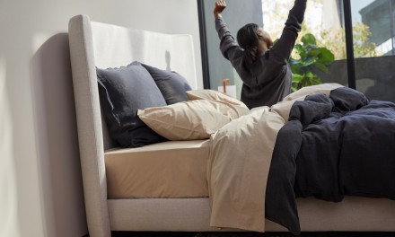 Woman stretching as she gets out of bed. 