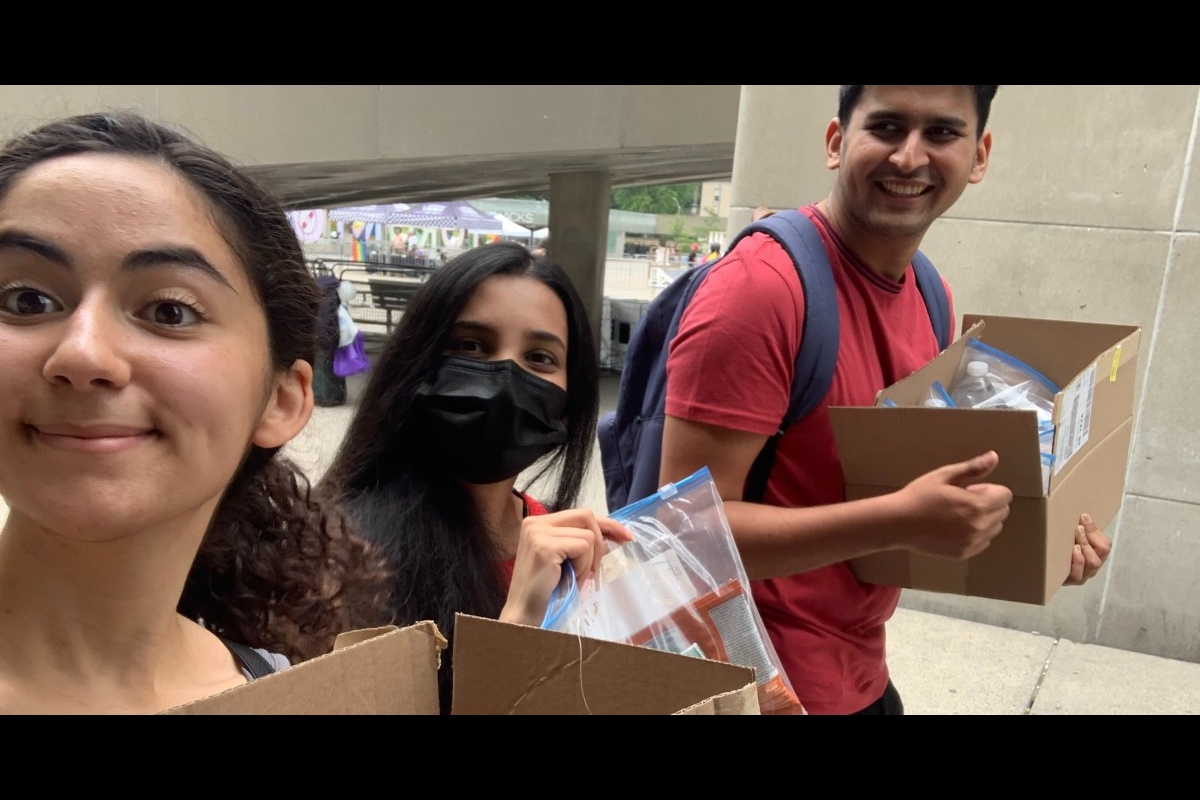 Members of the Blankets for T.O. executive team carry boxes of care packages for donation.