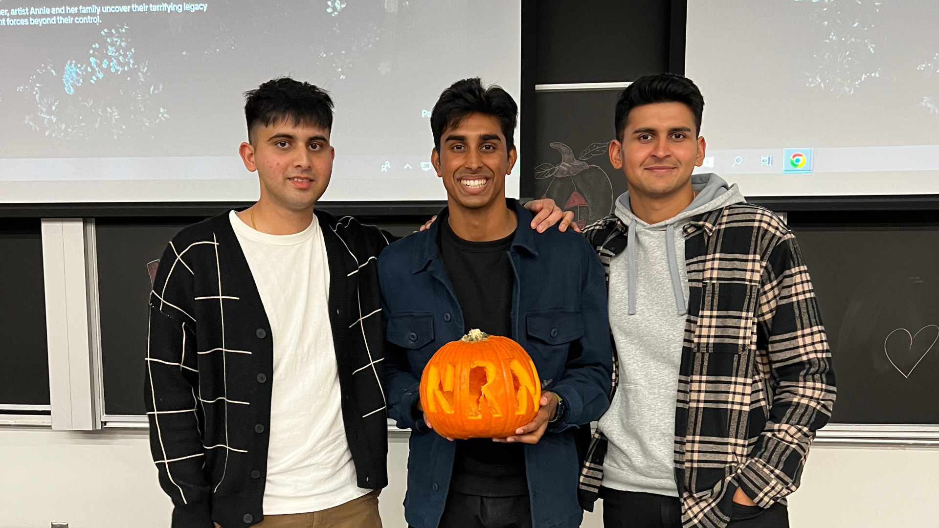 Our BTO co-presidents pose with their pumpkin carved with their initials during the 2022 Halloween Pumpkin Carving Night.