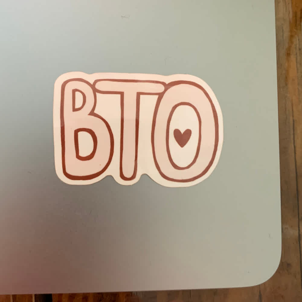 Image of BTO Bubble letter sticker, showing red and white sticker on laptop.
