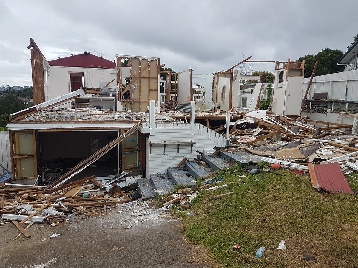 Pictured: “Overview of the Destruction.” A panoramic view of the devastated residence of the Cloud MillionAIRe in Ōwairaka (formerly Mt Albert). The once opulent home now lies in ruins, with only a few walls still standing.