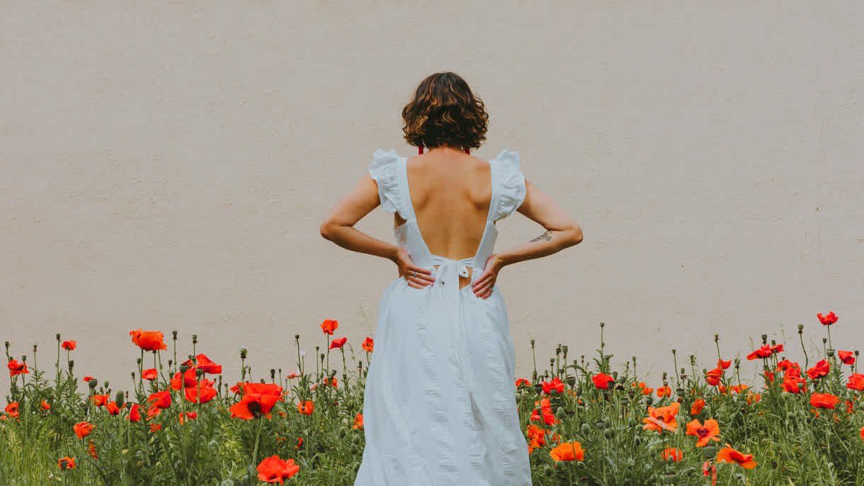 Photo of woman backwards with flowers in the bg