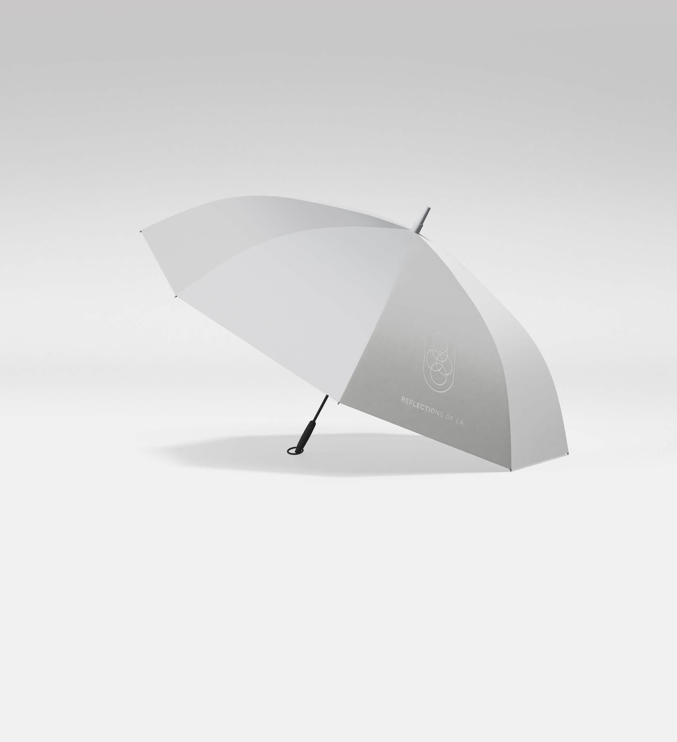 Experience elegance even on rainy days with the Four Seasons Los Angeles' bespoke umbrella. Its minimalist design, featuring a subtle gray gradient and the 'Reflections of LA' emblem, captures the hotel's luxurious essence, making it a must-have accessory for the style-conscious traveler.