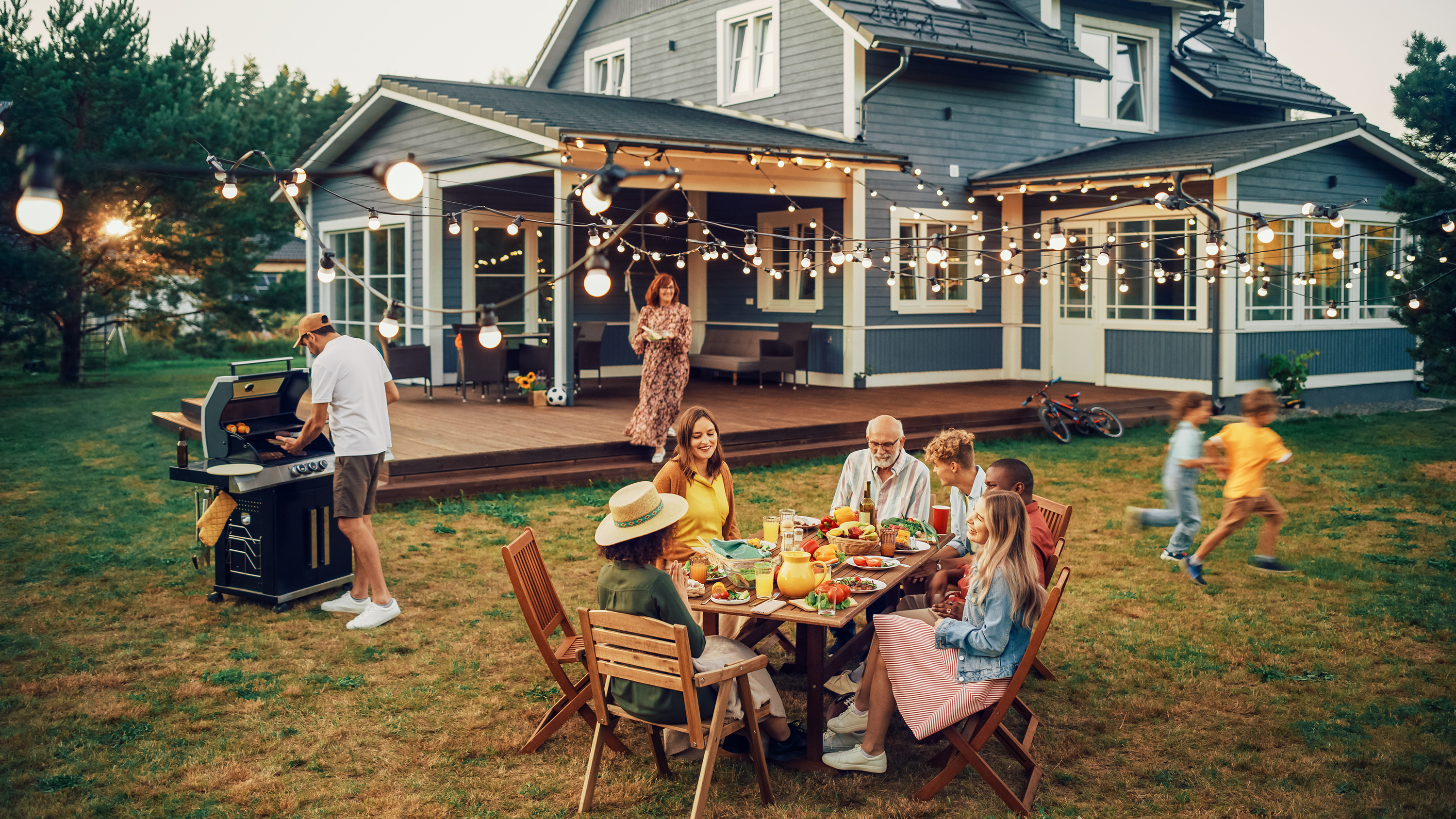 A family happily enjoying their patio and backyard during Memorial Day with neighborhood friends.