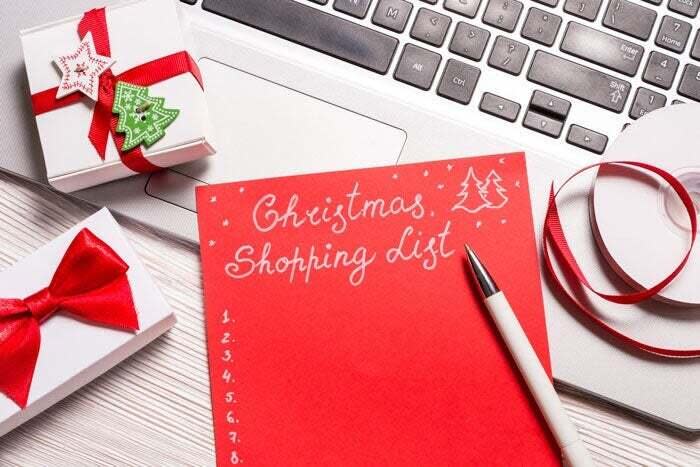 A holiday shopping list is laid out on a desk.