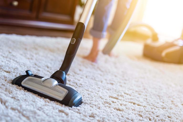 A woman vacuuming carpet