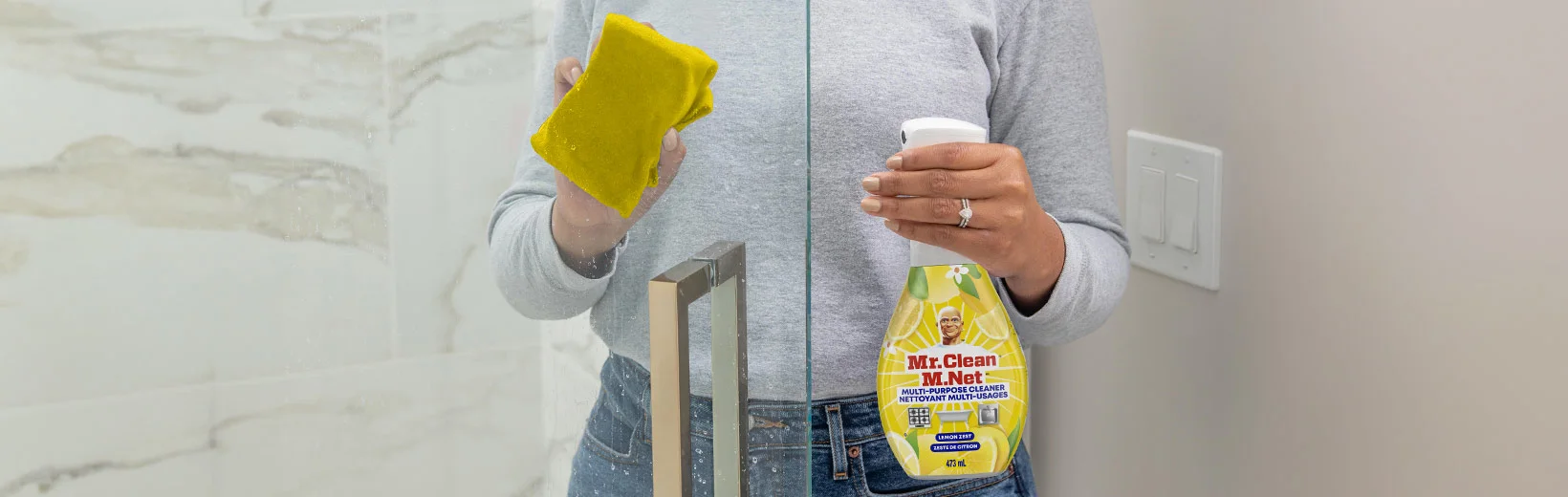 Woman cleaning shower glass door with Clean Freak