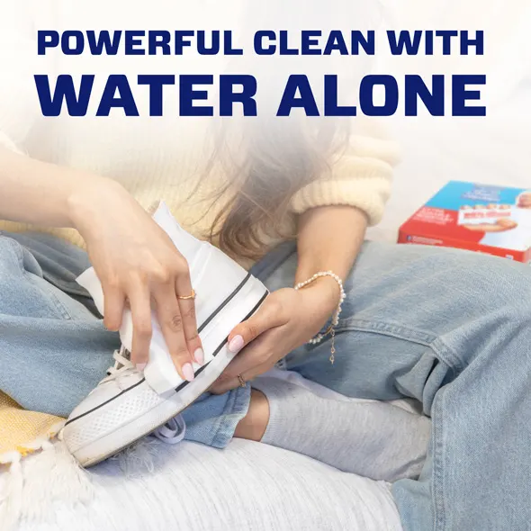 Person cleaning a sneaker using Mr. Clean Magic Eraser with water