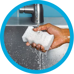 Washing Mr. Clean MagicEraser under a faucet