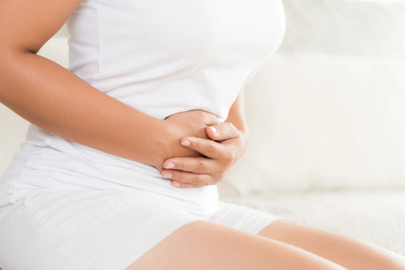 woman holding her stomach in pain