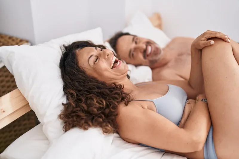 Couple Laughing in Bed