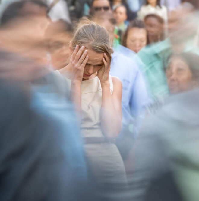 Woman having a headache in a crowd of people - menopausal side effects