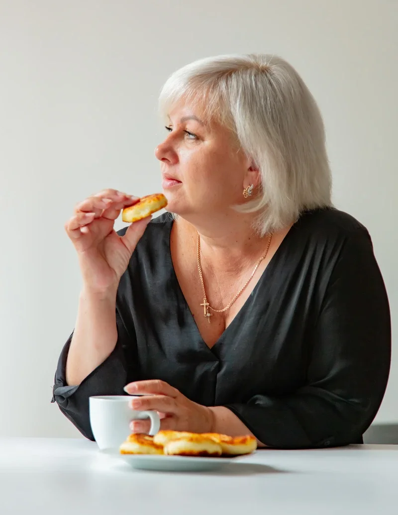 senior-ukrainian-woman-with-cup-and-cheesecake
