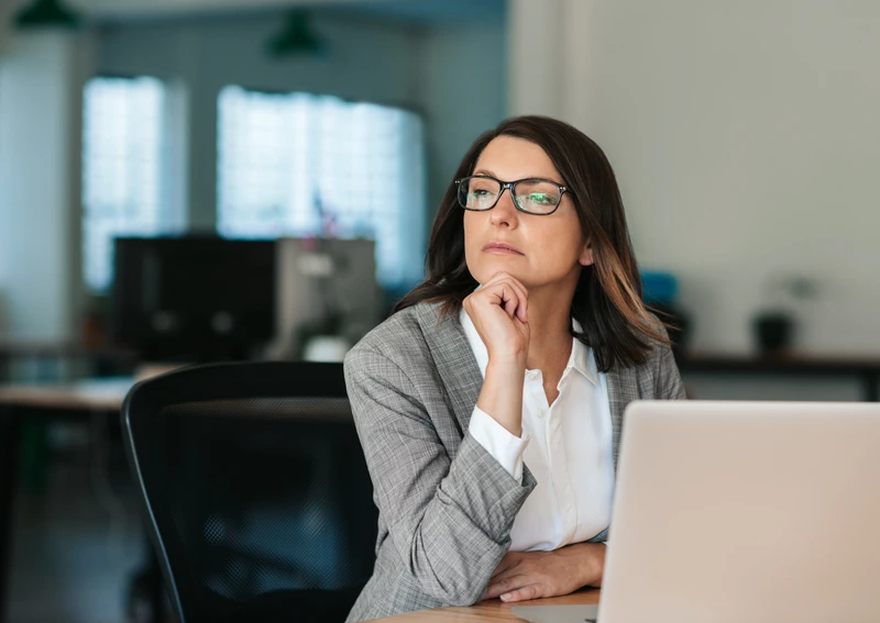 Woman in an office with sad look on her face.