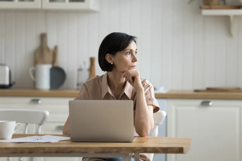 woman sitting in kitchen counter with computer
