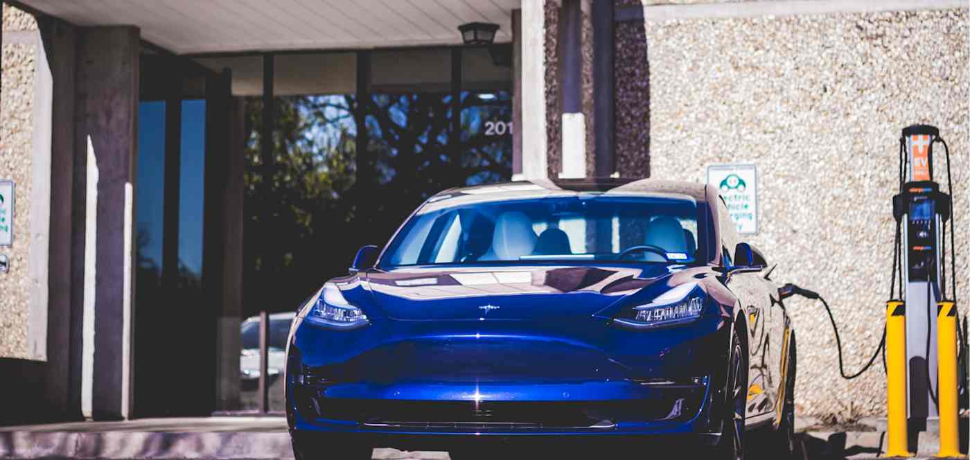 An electric car being charged by a Smart Charge America charger