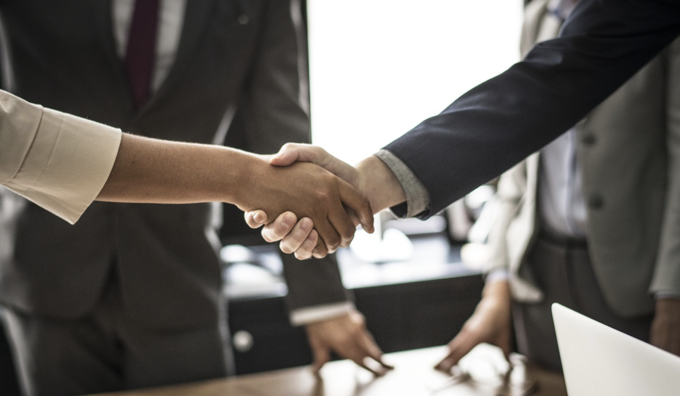 Two people shaking hands in a conference room