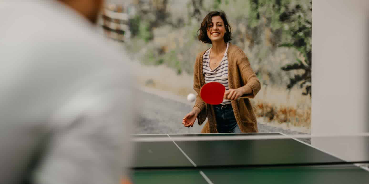 Hero image with a person playing table tennis, representing team building