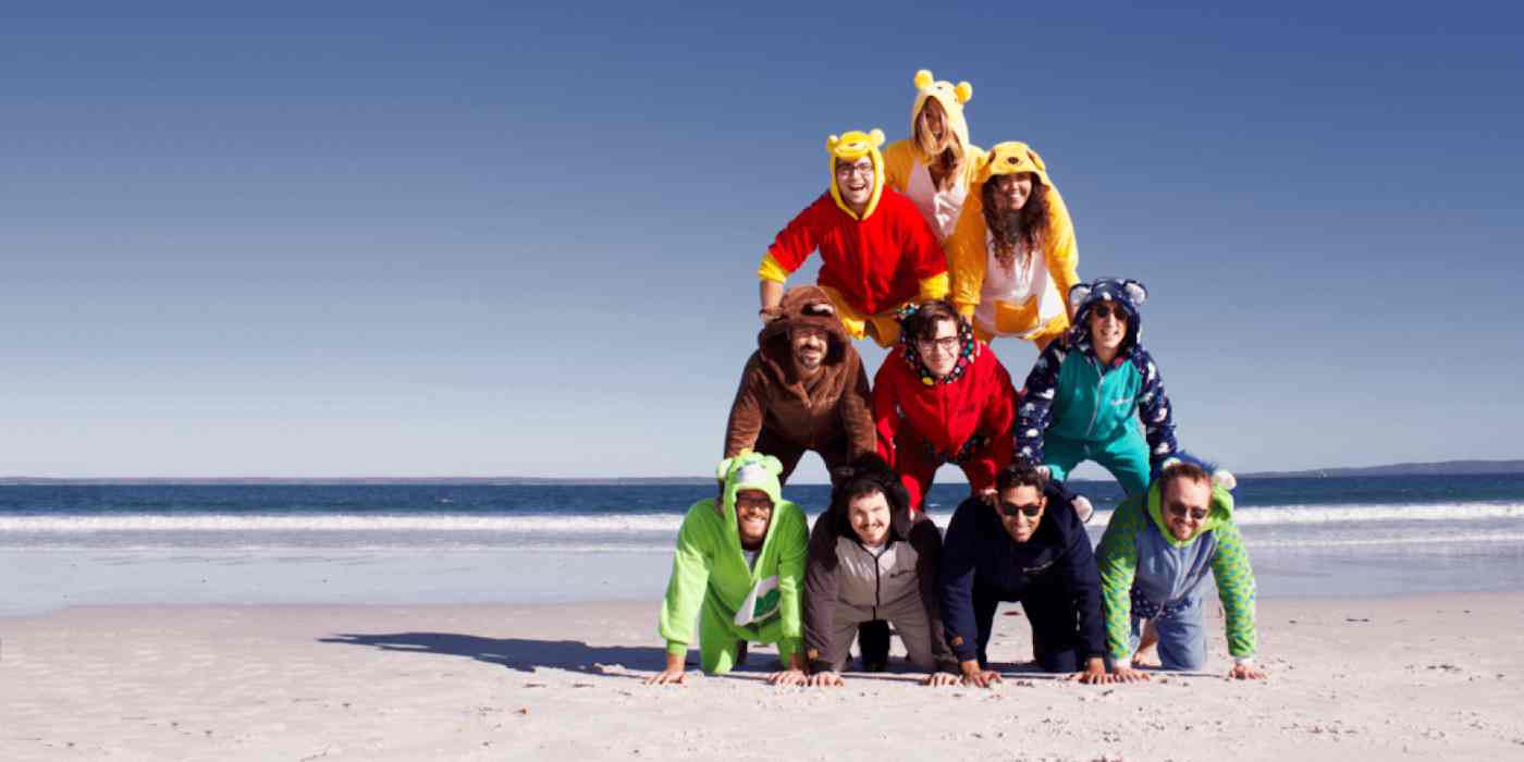 Screenshot of the Bonjoro team wearing costumes in a human pyramid on a beach