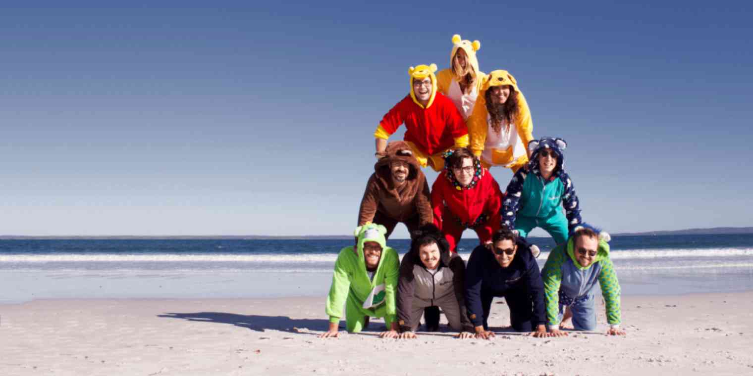 Screenshot of the Bonjoro team wearing costumes in a human pyramid on a beach