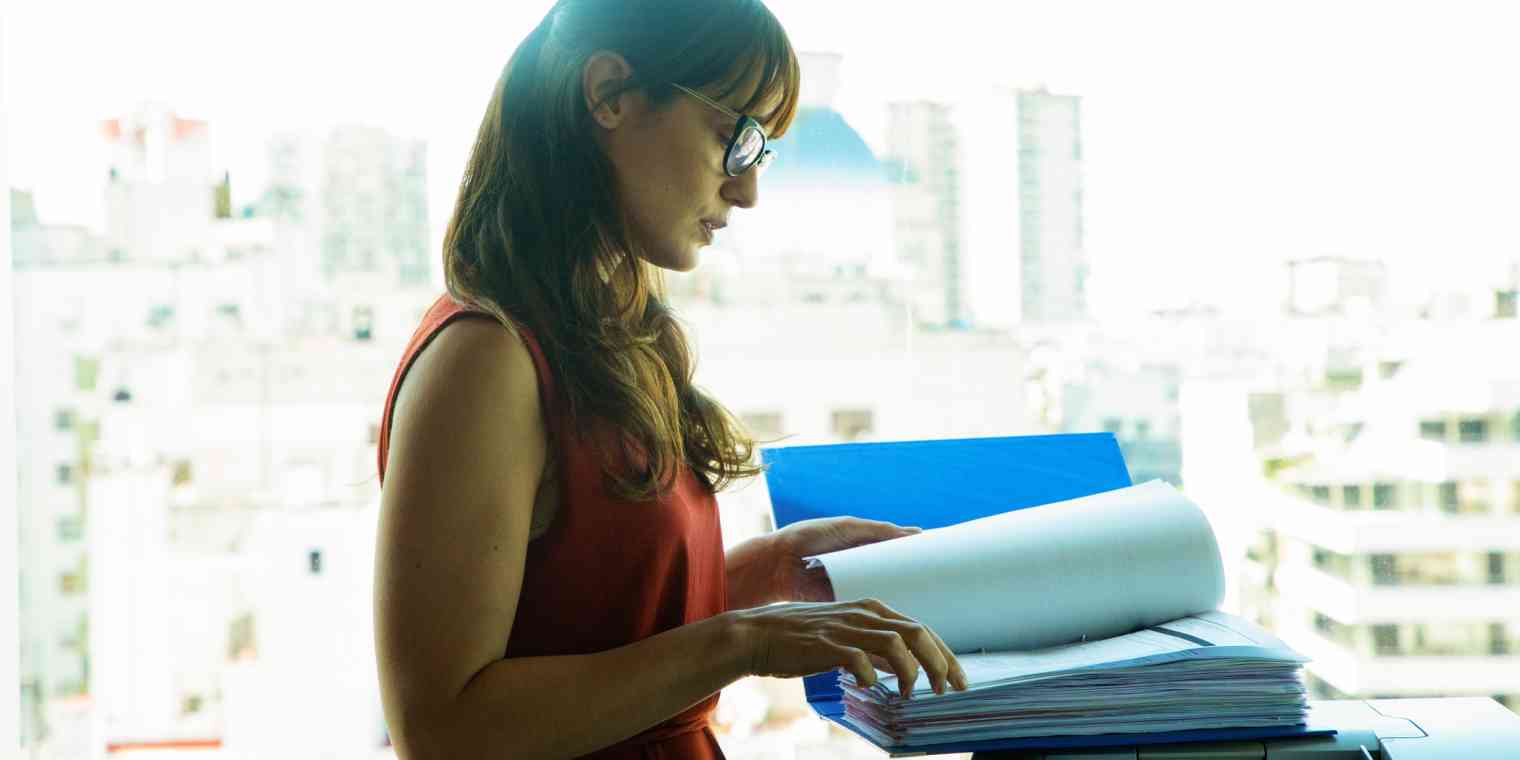 A woman at a copier with a large file.