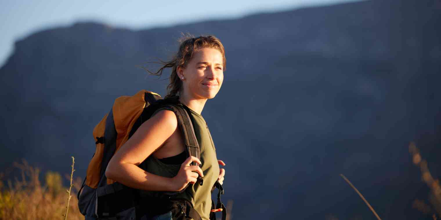 A hero image with a woman on a hike with a backpack