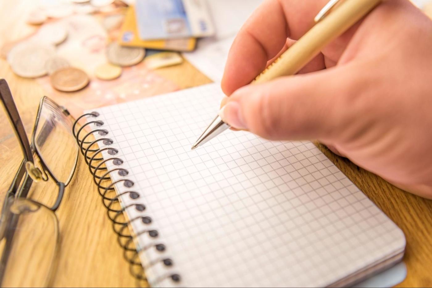 An image of a hand writing on graph paper
