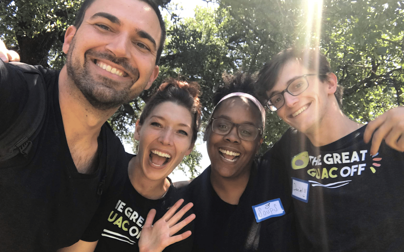 The author and three team members smiling at the camera. They are outside on a sunny day.