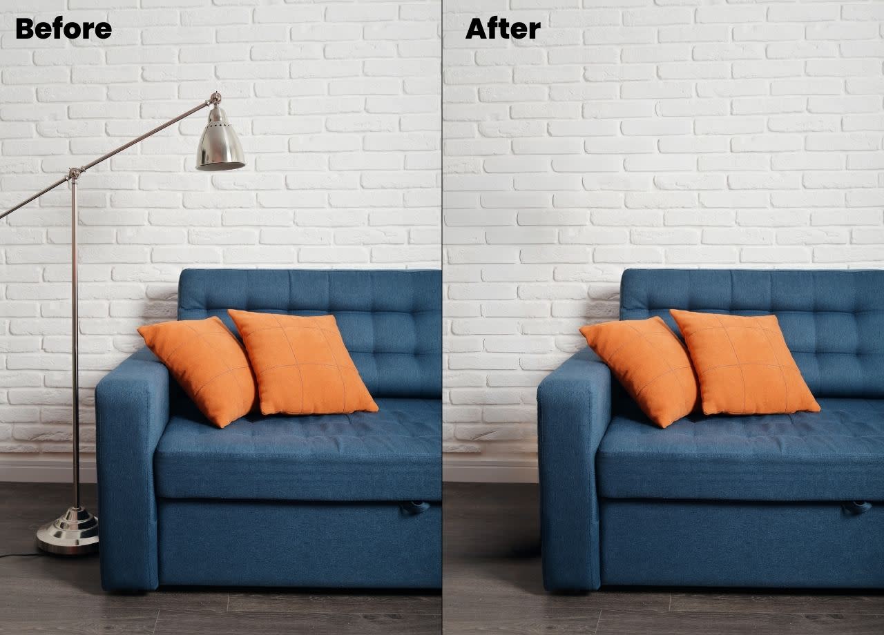 Before and after photo. The before photo shows part of a navy couch against a white, brick wall. The couch is decorated with two orange throw pillows, and there's a silver floor lamp beside the couch's arm.  In the after photo, the silver floor lamp has been edited out using Canva's Magic Eraser. 