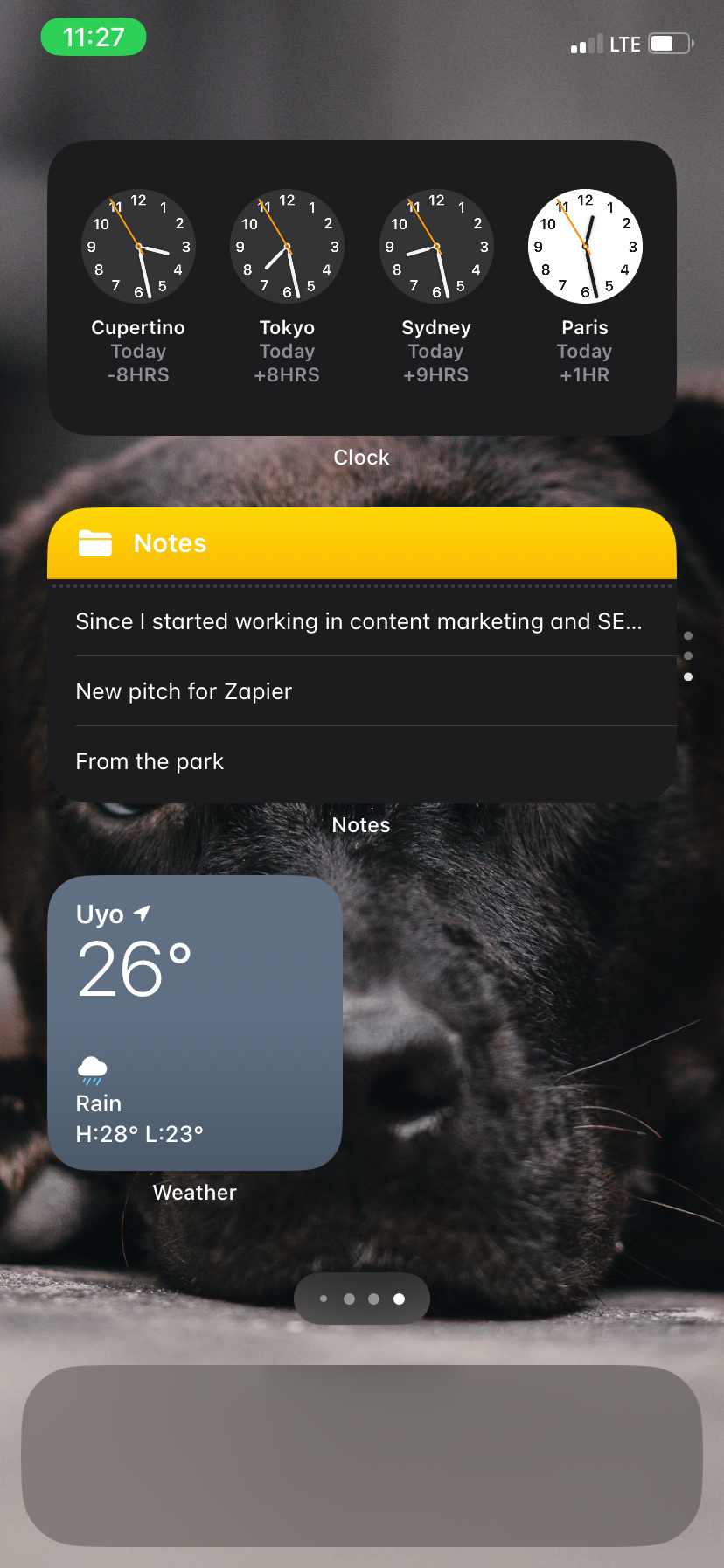 An iPhone home screen with three widgets on it: World Clock, Notes, and Weather