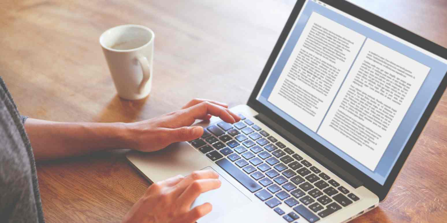 Hero image of someone's hands on a computer, typing a document