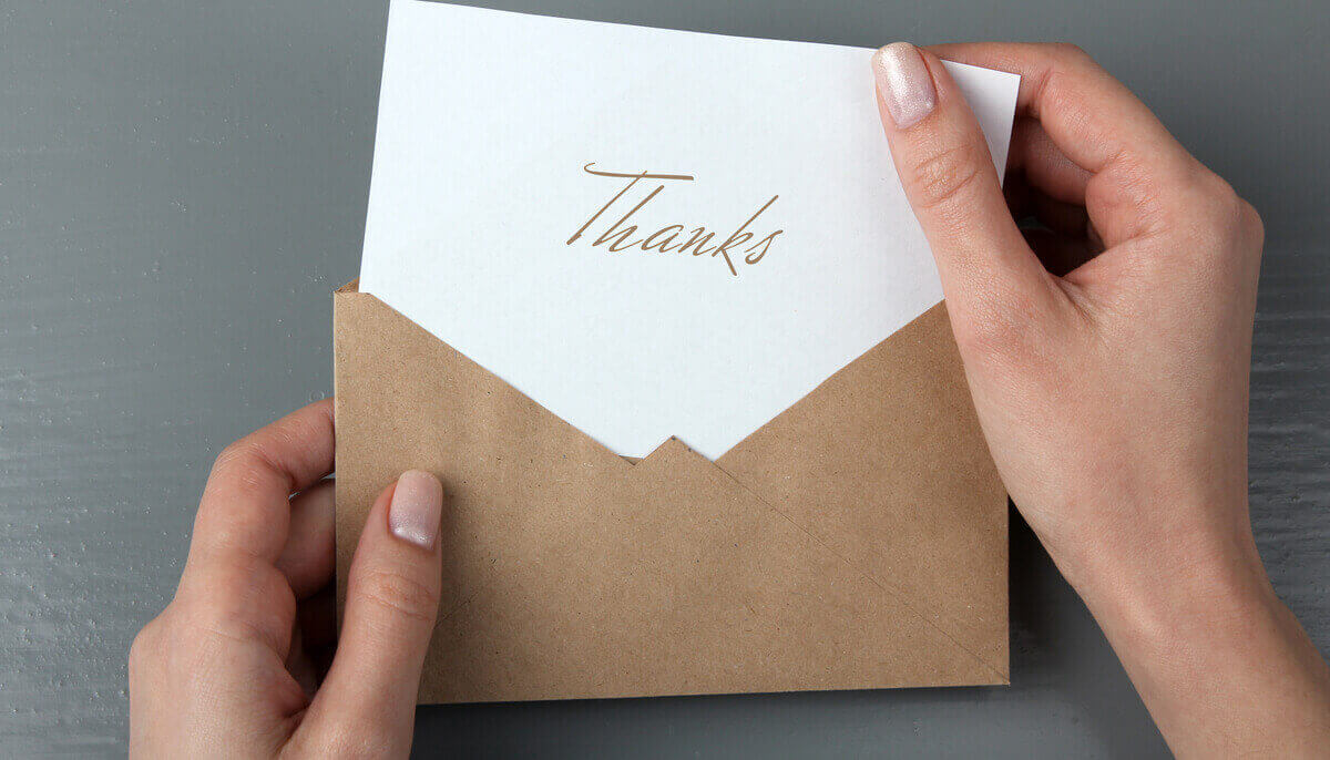 Someone opening a thank-you note