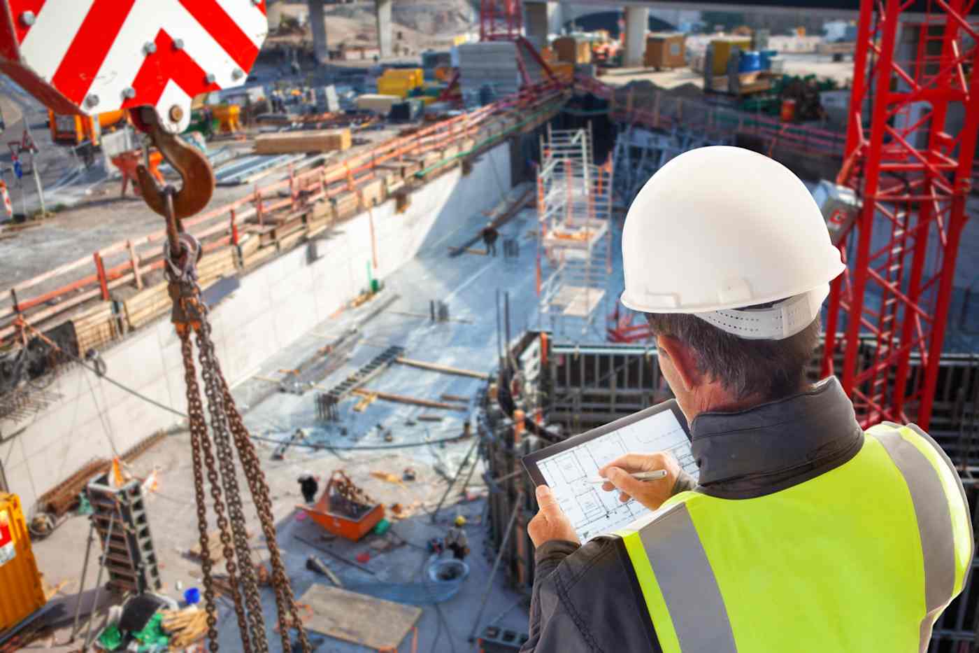 A male construction worker looks over a large building site.