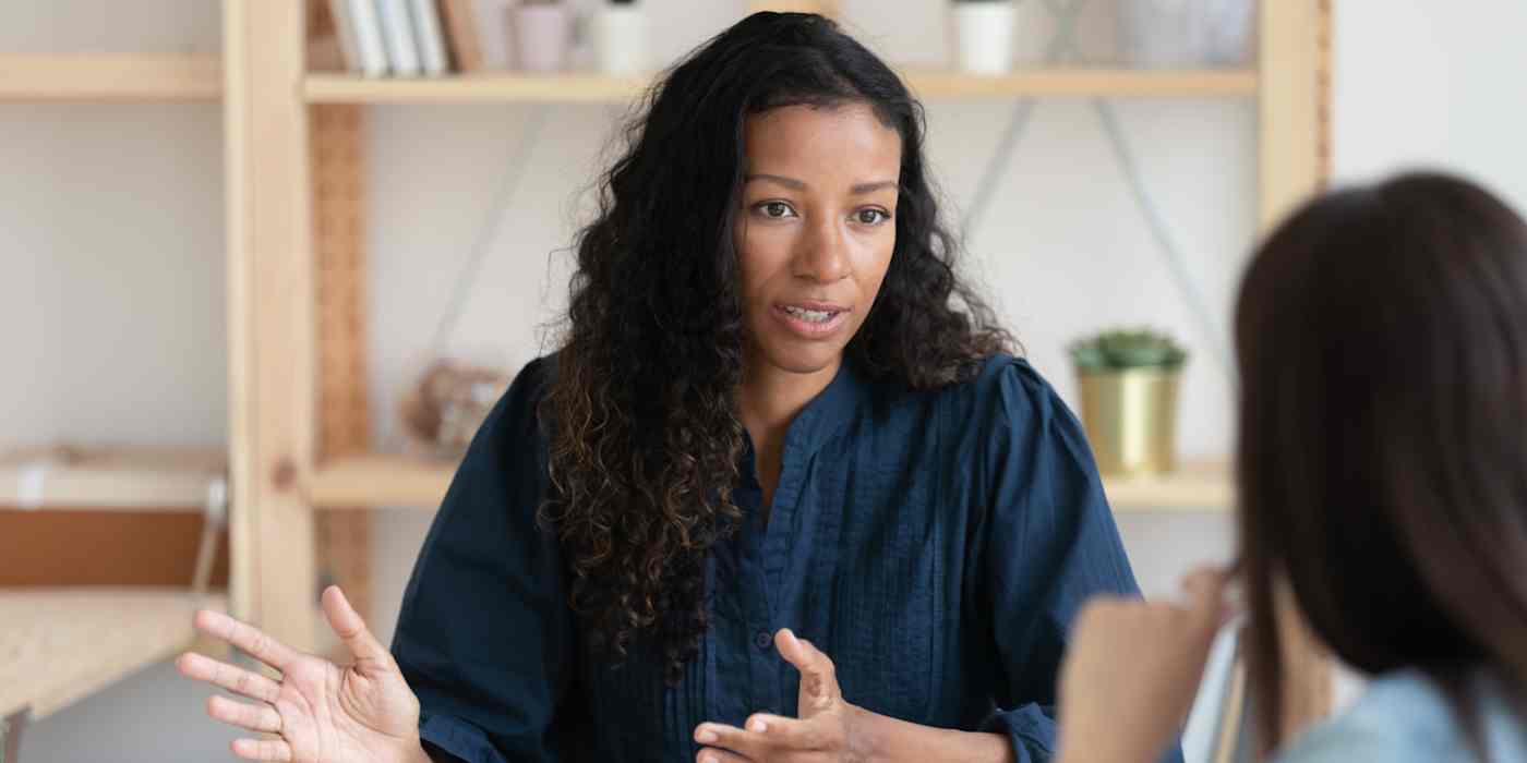 Hero image of a woman explaining something to another person