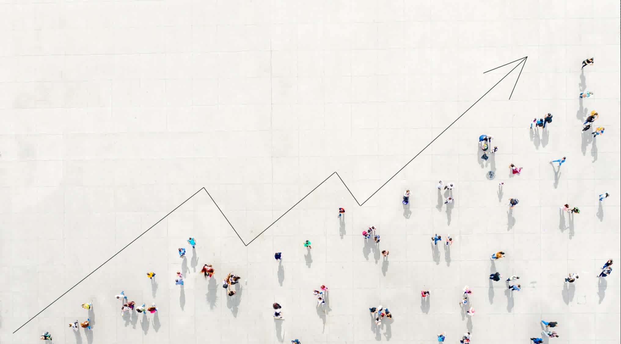 A well-spaced crowd of people on a white floor, with an upward trending arrow going from lower left to upper right.