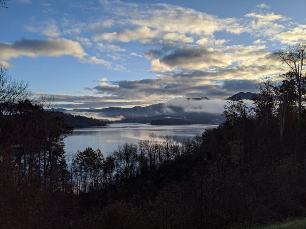 A serene picture of a lake with mountains in the background