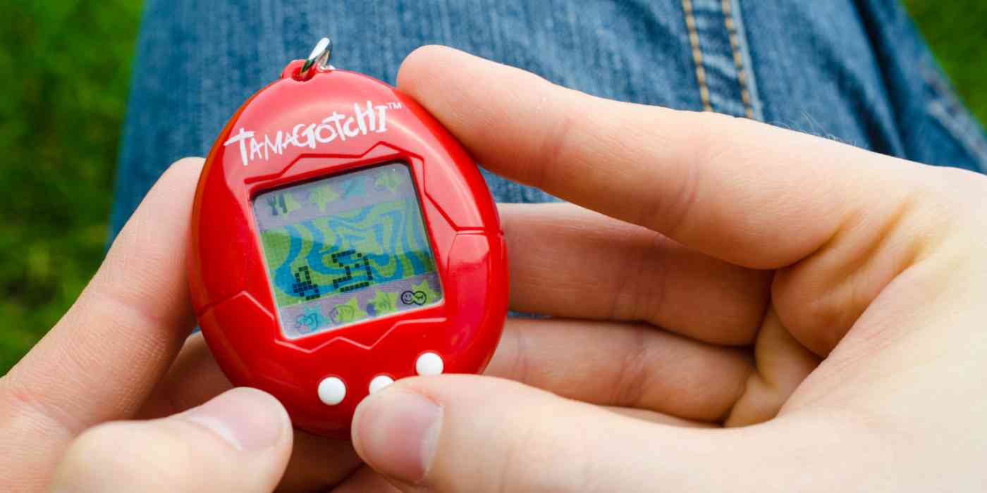Hero image of a person's hands holding a Tamagotchi