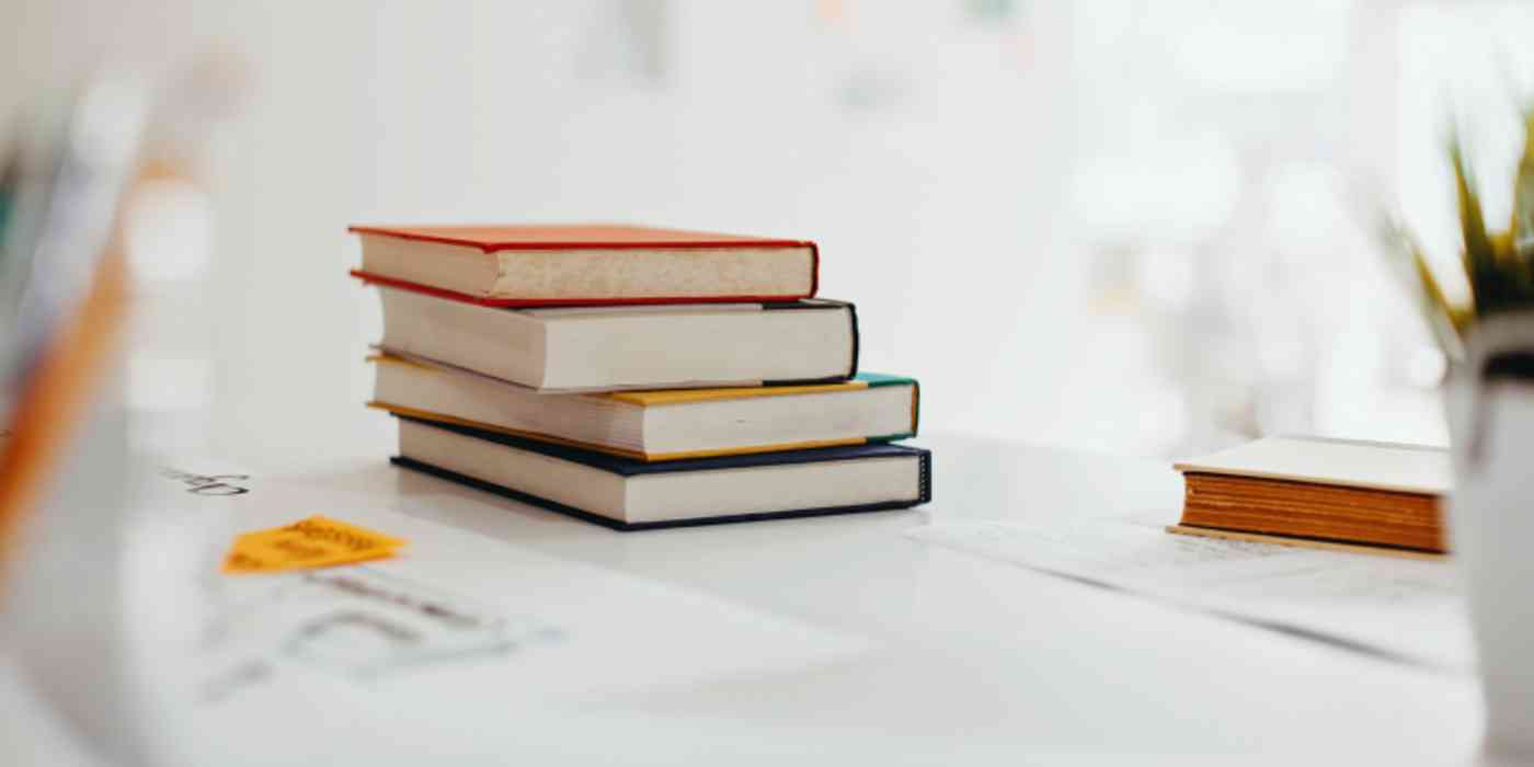 A hero image with a stack of books on a desk