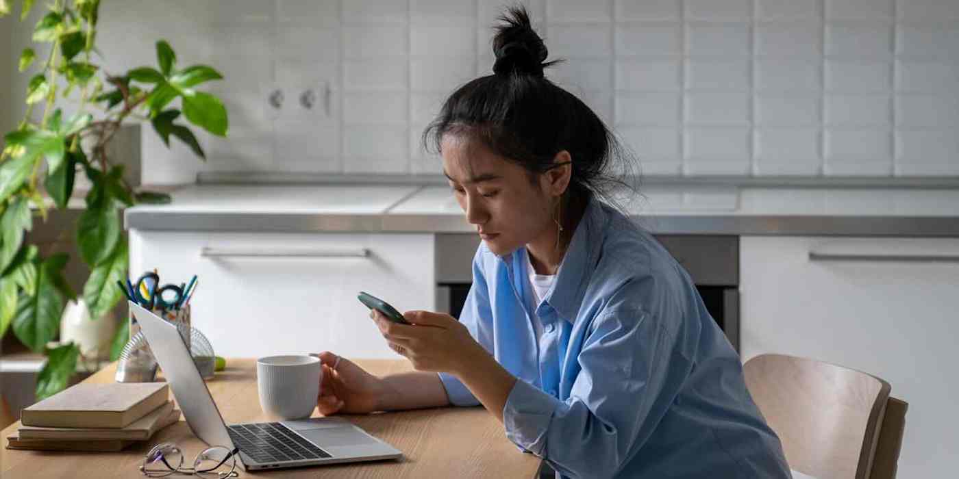 Hero image of someone at a desk looking at their phone