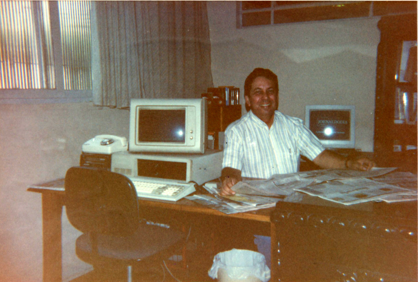 Laura's dad sitting at a desk with computers and papers