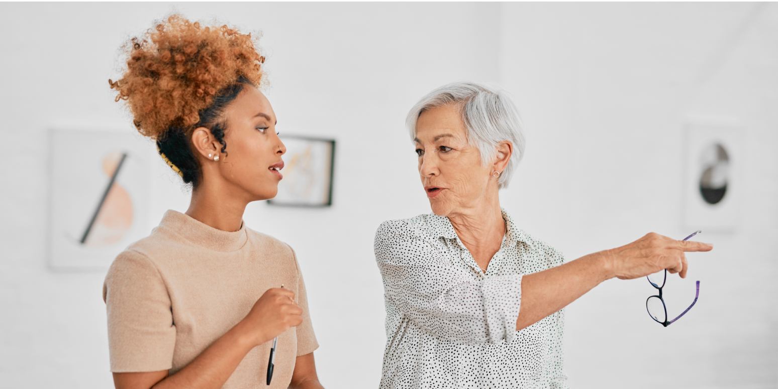 Hero image of two women in an art gallery; one is pointing something out to the other