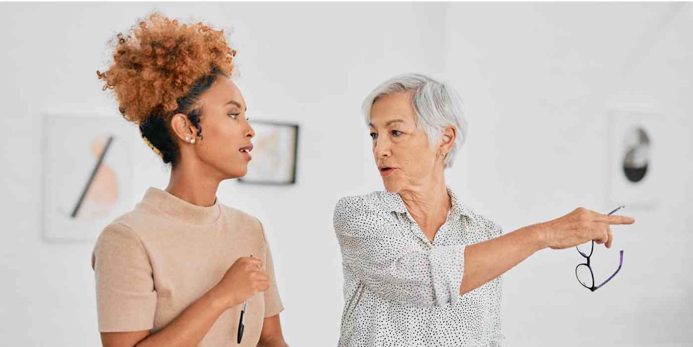 Hero image of two women in an art gallery; one is pointing something out to the other