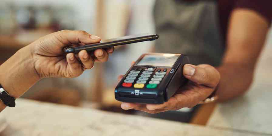 Hero image of someone paying with their phone, contactless