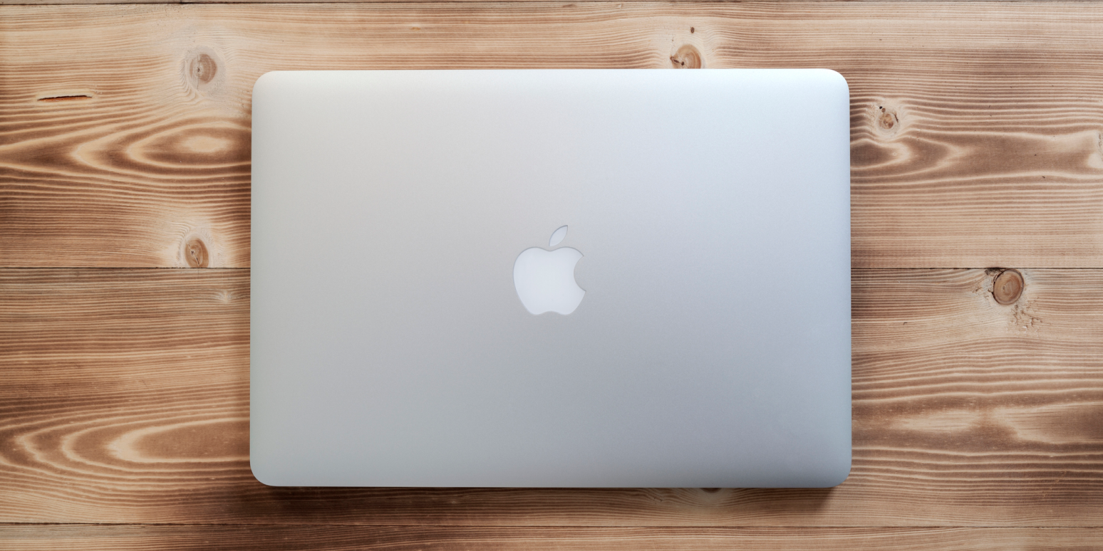 Hero image of a MacBook closed on a wooden desk