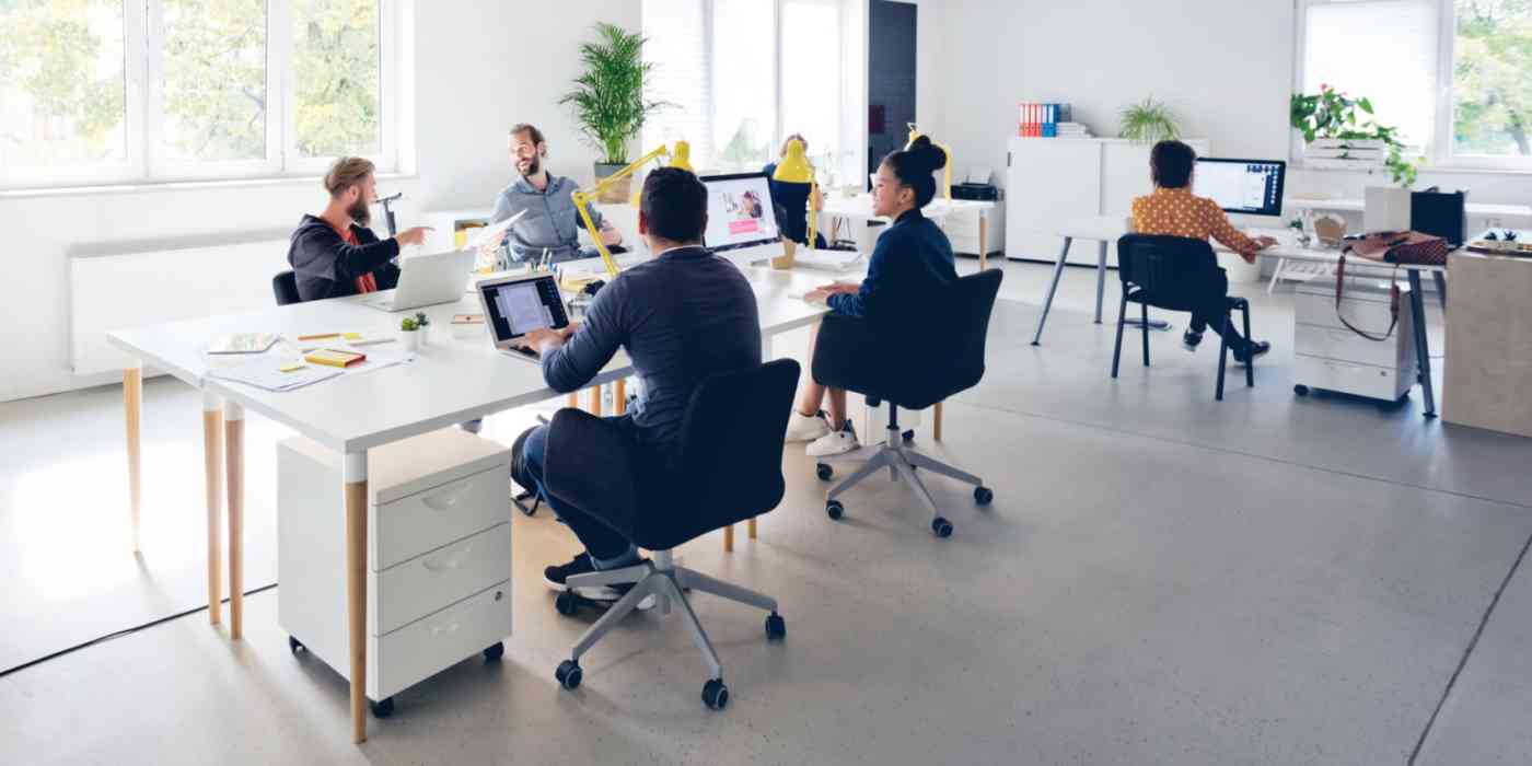 Hero image of a group of workers in an open, modern office