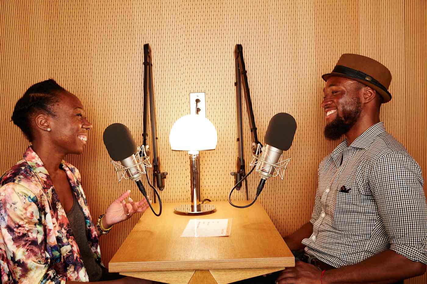 An interview with a woman and a man sitting at a desk with microphones. 