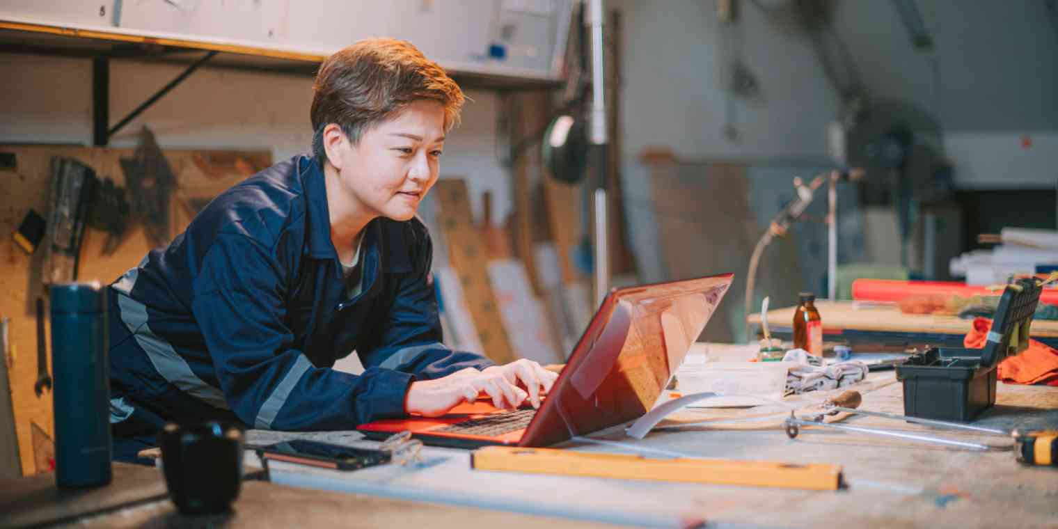 Hero image of a small business owner in a studio leaning over a computer