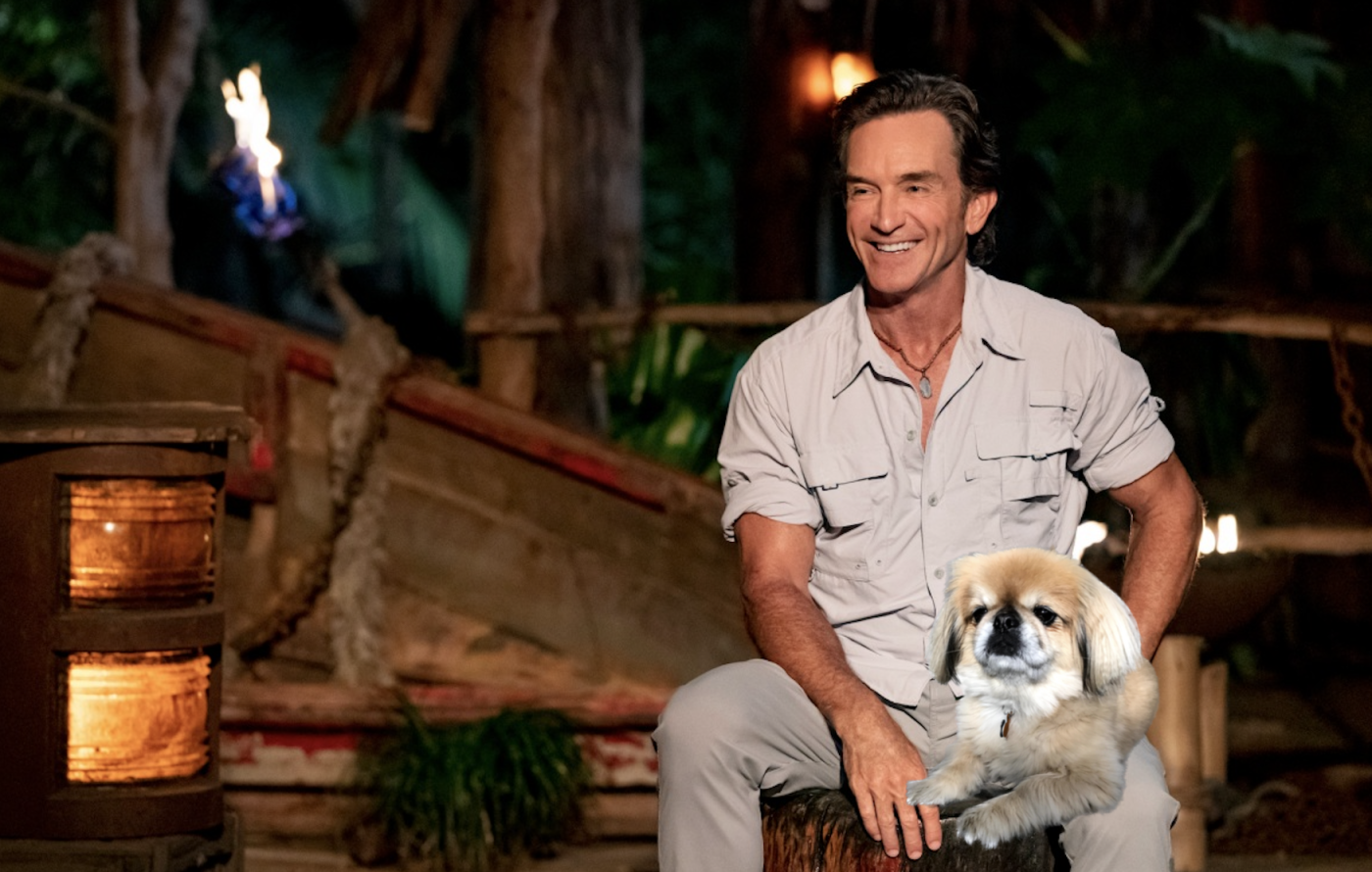 A dog sitting on Jeff Probst's lap 