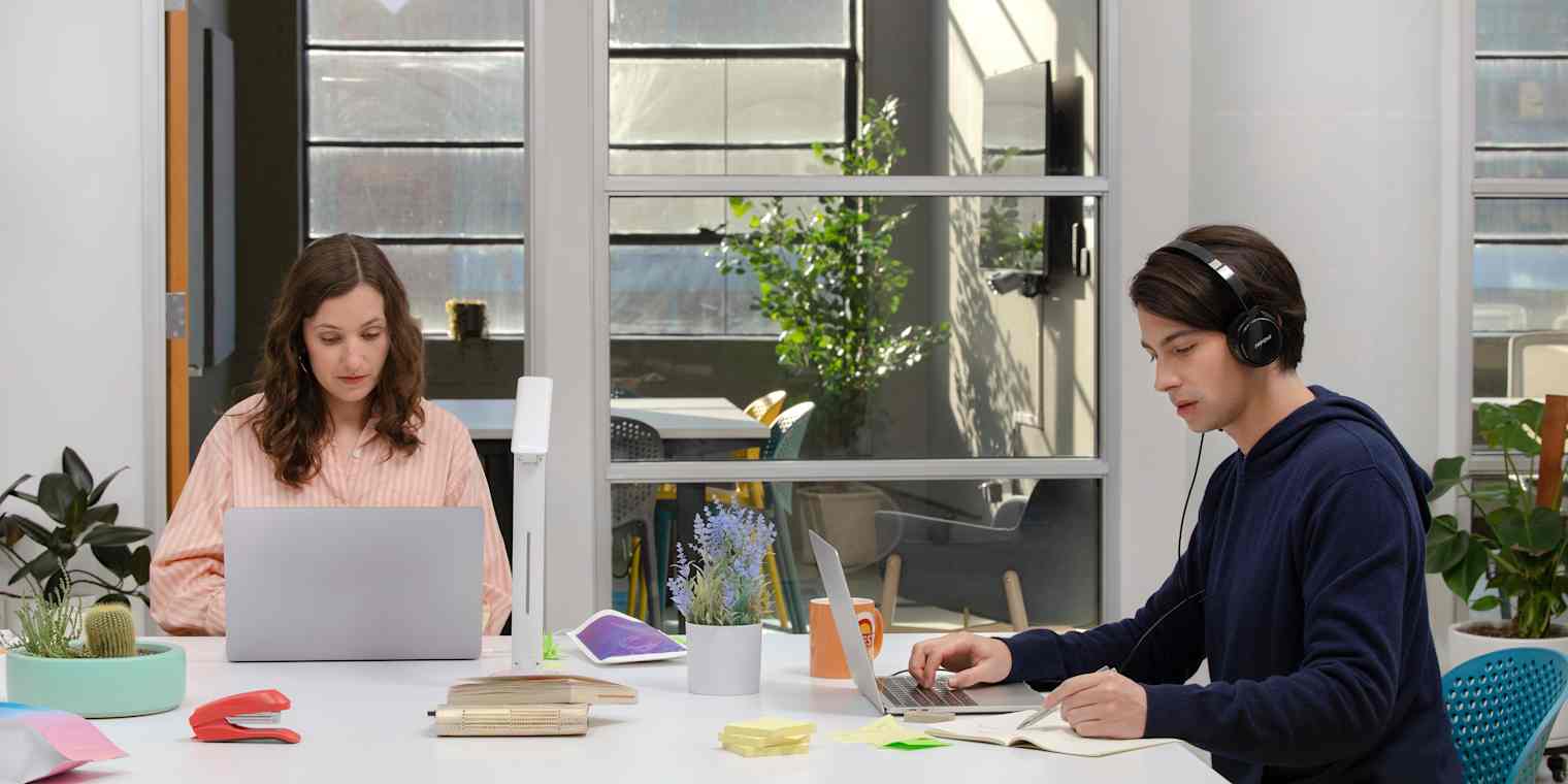 The Fellow team in their office, sitting at a table working on laptops
