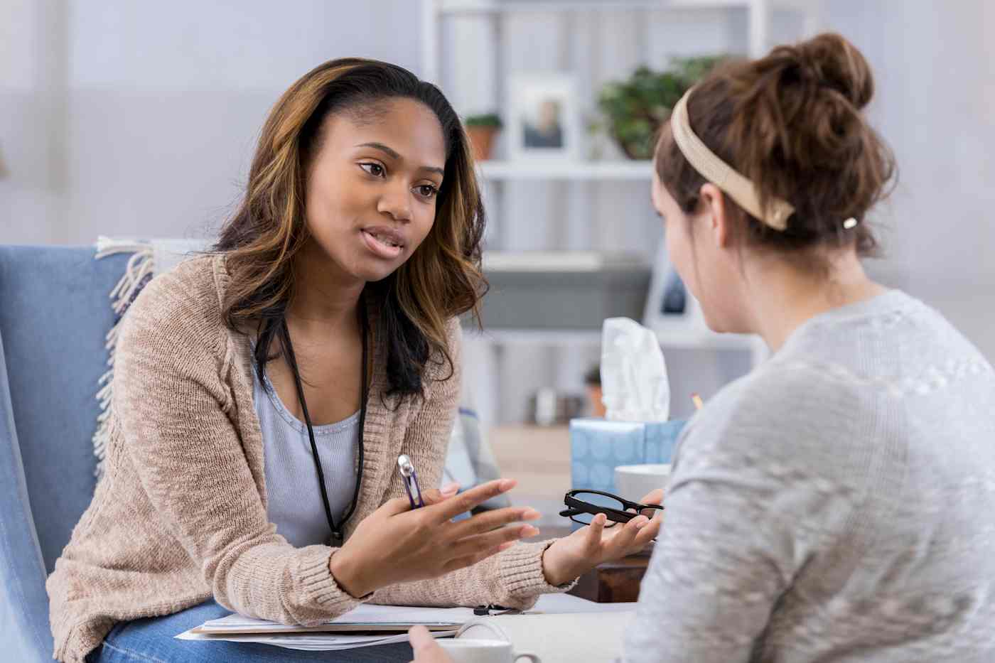 Hero image of two women talking, one of whom is gesticulating and holding a pair of glasses